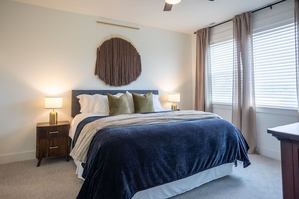 Cozy king bed with soft textures, moody lighting, and a modern-boho wall feature for ultimate relaxation.