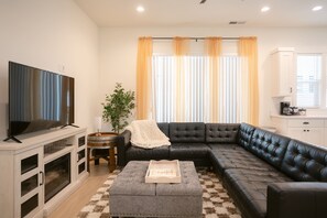 Spacious and stylish living area with a large sectional, perfect for movie nights and lounging in comfort.