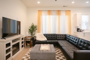 Spacious and stylish living area with a large sectional, perfect for movie nights and lounging in comfort.