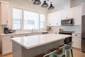Bright and modern kitchen with ample counter space and seating—ideal for cooking and gathering.