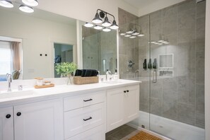 Sleek and modern ensuite featuring dual sinks and a luxurious walk-in glass shower.