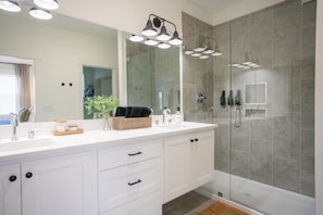 Sleek and modern ensuite featuring dual sinks and a luxurious walk-in glass shower.