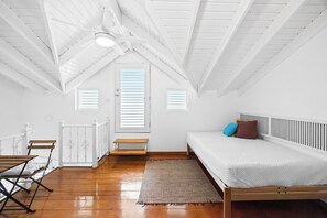 Cozy and clean bedroom with soft linens, air-conditioning, and serene white decor – your peaceful home base for a restful sleep.