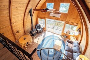 Natural light floods the cabin’s A-frame interior, offering panoramic views from every corner.