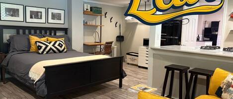 Studio apartment with queen bed, desk, fast wifi, smart TV, and kitchen.
