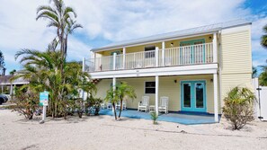 The front of home showing the lower porch and upper balcony for units A (Holmes Hideaway) and B (Holmes Getaway).