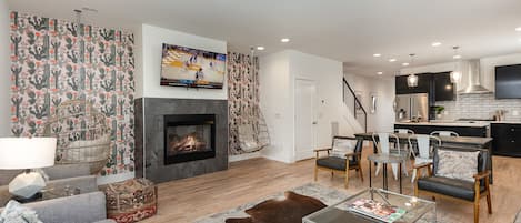 Open-concept living area with cozy furnishings, a Smart TV, and a fireplace.