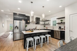 Fully Equipped Kitchen with stainless steal appliances, bar seating, and a dining area.