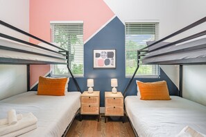 Fourth Bedroom invites fun and relaxation with two twin-over-full bunk beds, plush linens, and playful décor.