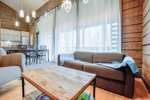 Warm and inviting living room/dining room with a fireplace & sofabed — perfect for relaxing after a day of exploring.