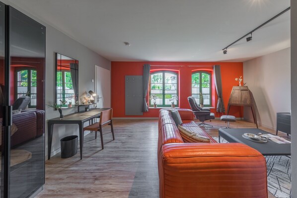 Ferienwohnung Schwalbenblick rote Couch und Schreibtisch