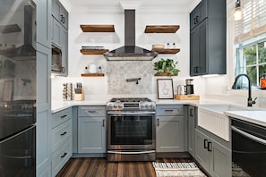 A stylish kitchen with sleek gray cabinets and warm wood accents. Imagine preparing delicious meals in this well-equipped space.