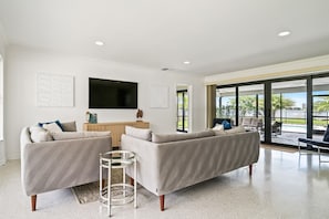 Bright and spacious living area features comfortable modern sofas and large sliding glass doors that bring the outdoors in.