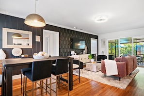 Open-concept living space showcases a modern dining area flowing into a bright living room with comfortable seating.