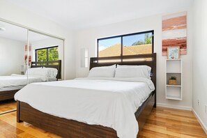 Another comfortable bedroom featuring a plush bed, large windows, and thoughtful decor for a pleasant stay.

