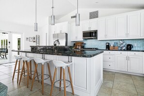 Modern kitchen with a large island and bar stools, ideal for casual dining and socializing.


