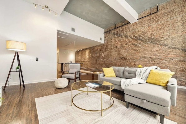 A welcoming living room with modern decor, and ample natural light, perfect for relaxation.