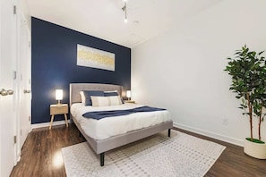 A serene bedroom with a comfy queen-size bed and premium linens, curtains for restful nights.