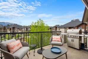 Private balcony with outdoor seating and mountain views.