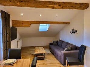 Ferienwohnung Bergblick 45 qm f. 1-2 Personen, ruhige zentrale Lage.-Sofa mit Tisch und Flachbildfernseher 50 zoll