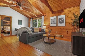 Open concept living with pull out couch, smart tv, board games, pellet stove, and stocked kitchen. Please note this cabin has a window AC unit and portable fans only. There is no central air in the small cabin.