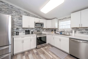 The open, airy kitchen offers ample space & every home comfort