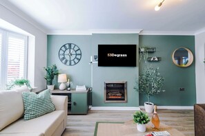 The spacious open-plan living space benefits from a sofa bed, a 55-inch smart TV and plenty of space to sit down and relax.