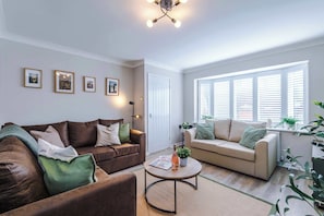 The spacious open-plan living space benefits from a sofa bed, a 55-inch smart TV and plenty of space to sit down and relax.