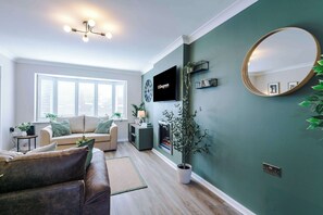 The spacious open-plan living space benefits from a sofa bed, a 55-inch smart TV and plenty of space to sit down and relax.
