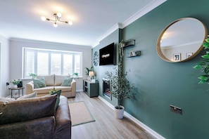 The spacious open-plan living space benefits from a sofa bed, a 55-inch smart TV and plenty of space to sit down and relax.