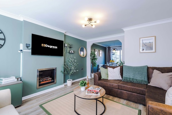 The spacious open-plan living space benefits from a sofa bed, a 55-inch smart TV and plenty of space to sit down and relax.