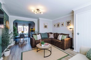 The spacious open-plan living space benefits from a sofa bed, a 55-inch smart TV and plenty of space to sit down and relax.