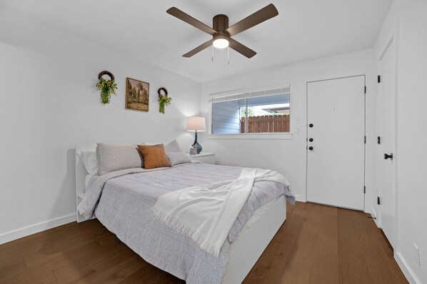 Comfy bed, closet, simple decor, with bathroom and back door access.