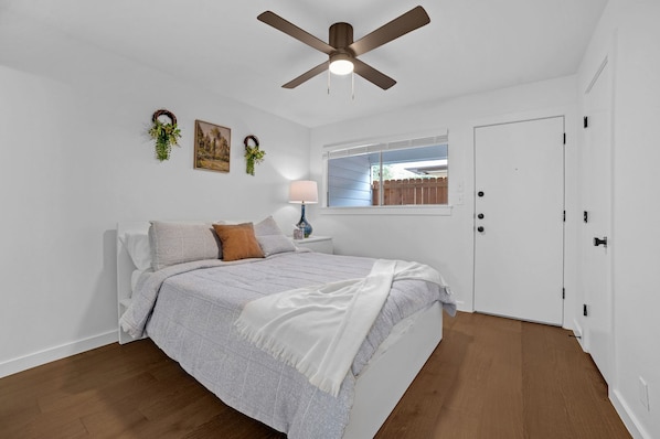 Comfy bed, closet, simple decor, with bathroom and back door access.