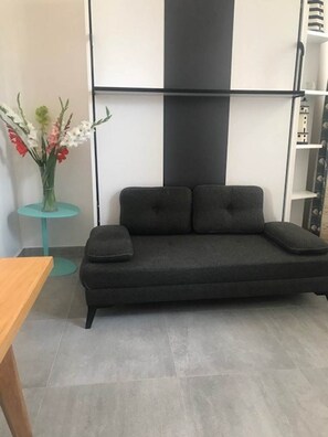 Studio – Coin salon avec charme rétais Ambiance chaleureuse et touche marine dans cet espace modulable en plein centre piéton. Confort assuré pour un séjour paisible à La Flotte