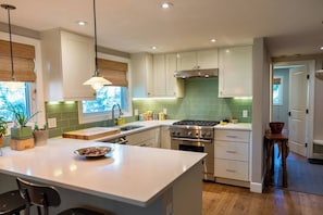 Gourmet kitchen with Thermador gas range and counter seating for two.