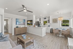 Bright, open living area with a cozy blue sofa and a modern kitchen.