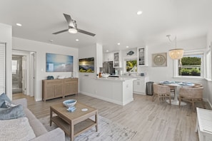 Bright, open living area with a cozy blue sofa and a modern kitchen.