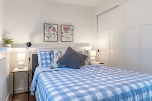 The bedroom serves as a restful sanctuary with generous closet space and a bright, minimalist aesthetic that enhances the open, refreshing atmosphere