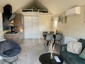 Wohnzimmer mit offener Einbauküche und Essbereich.