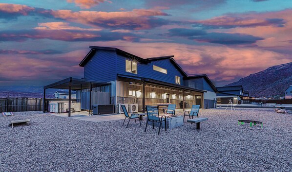 Huge yard with games for families, seating around a firepit, and the hot tub