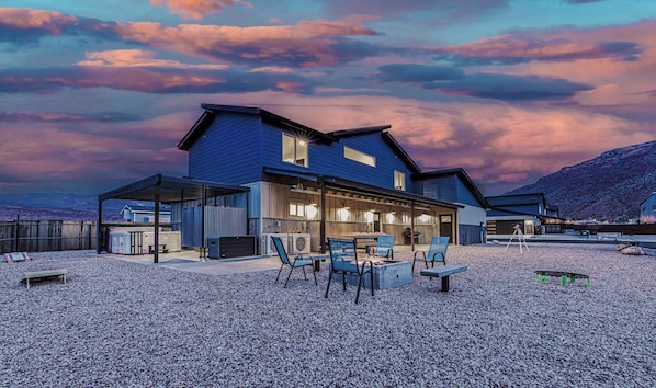 Huge yard with games for families, seating around a firepit, and the hot tub