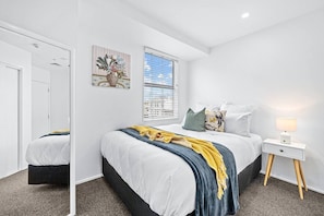 The Queen bed is bright and colourful with both a blue and yellow throw.
