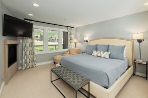 A king bed in the Primary bedroom with a large smart TV and in room fireplace