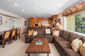 Open living space featuring oversized sectional, live-edge coffee table, and gourmet kitchen. Dining for 6 and large windows with mountain views make this perfect for groups.