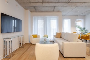Spacious lounge with sleek TV and natural light