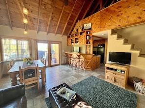 Living Room 1 with Smart TV, fireplace, dining table, love seats & family games