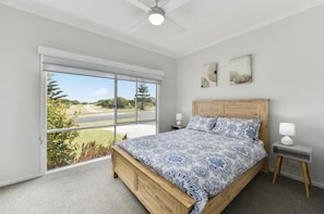 Comfortable second queen bedroom with open wardrobe storage