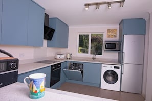 The kitchen has coffee machine, dishwasher, microwave and induction hob