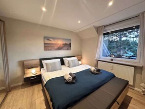 Schlafzimmer mit 180er Doppelbett, großem Kleiderschrank und Smart TV.